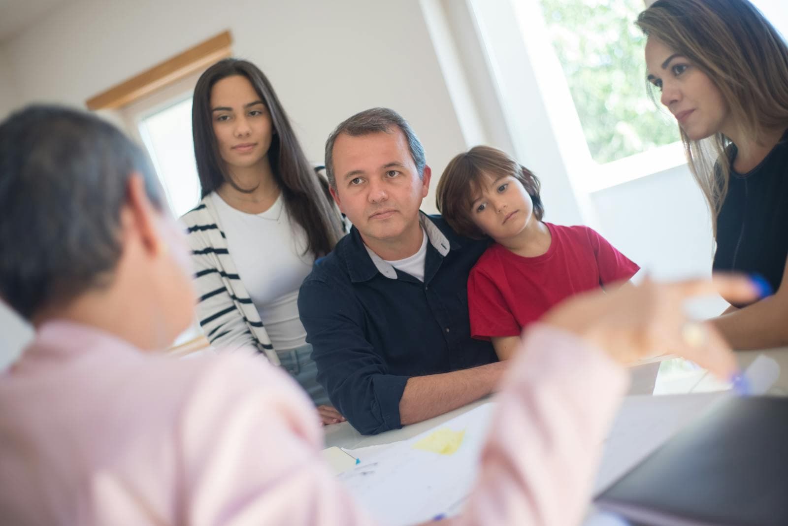 A family meets with a professional at home to weigh trusted senior care options.